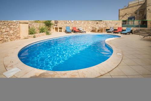 纳杜尔3 Bedroom Farmhouse with Private Pool & Views in Nadur Gozo的庭院里的一个蓝色的大型游泳池