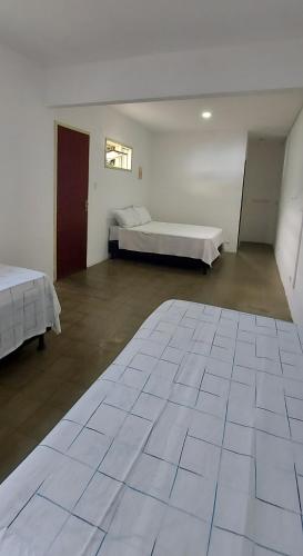 马拉戈日Pousada Esmeralda的大房间设有两张床和大型瓷砖地板