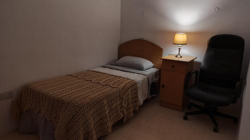 圣保罗湾城Your room的一间卧室配有一张床、一张桌子和一把椅子
