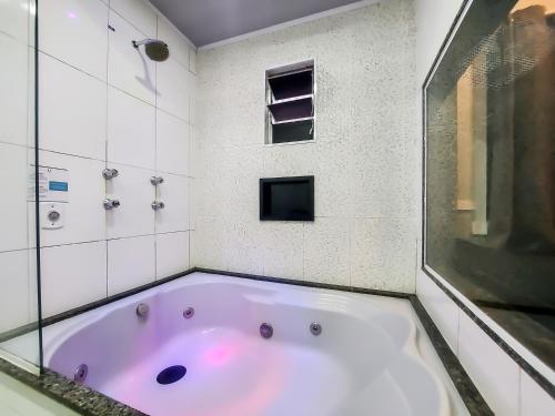 圣保罗Único Motel Faria Lima的带浴缸的浴室和窗户