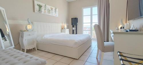 Monastir守护神酒店的白色的客房设有一张床铺和一张桌子以及一间厨房。