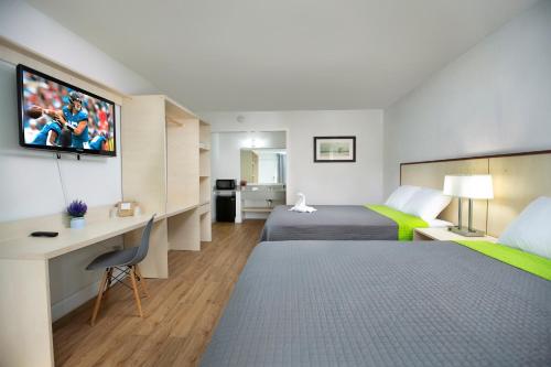 Weekly Inn的酒店客房设有两张床、一张桌子和一台电视。