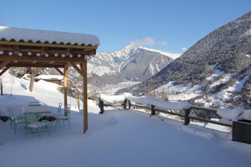 奥西耶尔La Grange de Soulalex的雪地凉亭配有桌椅