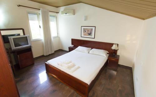 地拉那Vila 57 HOTEL的一间卧室配有一张床和一台电视。