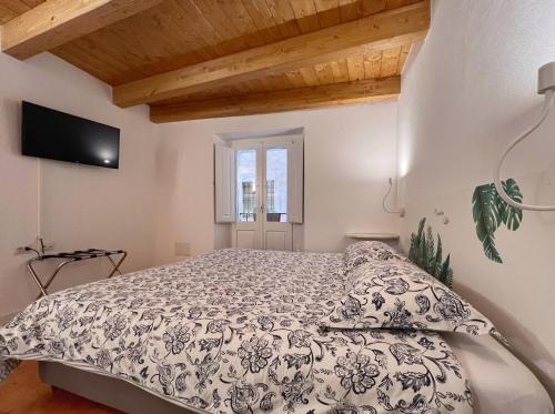 卡利亚里Al Duomo di Cagliari的卧室配有一张床,墙上配有电视。