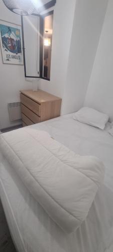安格勒Bel appartement avec balcon的一间卧室配有一张白色床、梳妆台和镜子