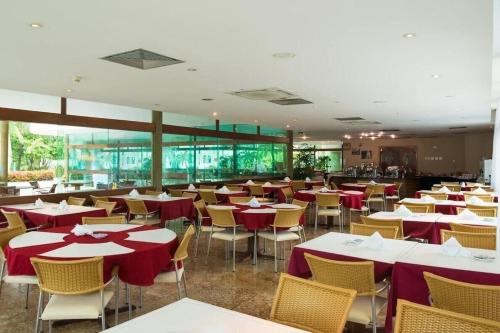 嘎林海斯港Marulhos Suites Resort的餐厅配有桌椅和红色桌布