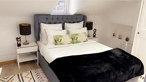 布鲁塞尔Calme, agréable et fonctionnel的一间卧室配有一张带蓝色床头板和枕头的床。
