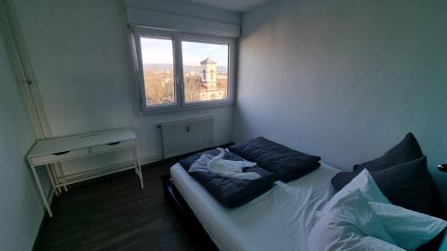 圣路易Dreamy Suite for Sunsetlovers的一间卧室配有一张床、一张书桌和一个窗户。