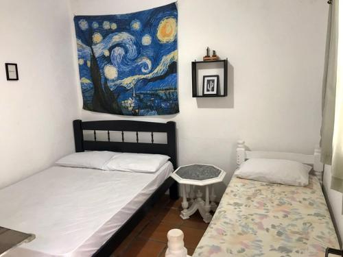伯迪亚哥SURFuncional Guest House的一间卧室设有两张床,墙上挂着一幅画