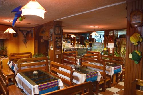 帕帕亚克塔La Quiteñita Papallacta的一间带木桌椅的餐厅和一间酒吧