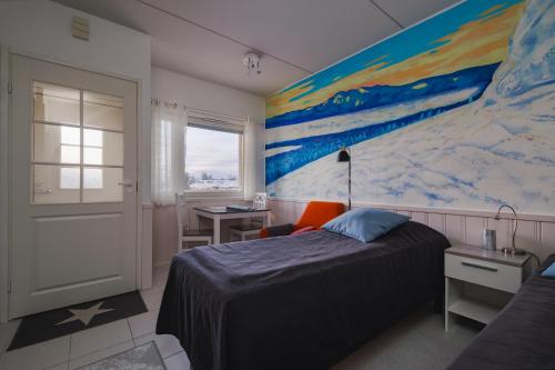 基蒂莱Pikkuriikkinen yksiö kaikilla herkuilla Levin keskustassa的卧室配有一张床,墙上挂有绘画作品