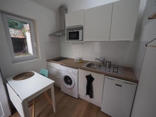 日安Appartement meublé 4 - 15 min Dampierre - 25 min Belleville - WIFI的一个带水槽和洗衣机的小厨房
