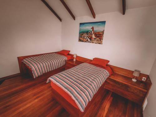Isla de SolEcolodge Santo Campo的铺有木地板的客房内的两张床