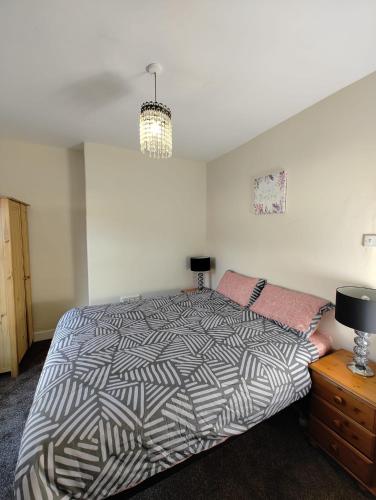 利物浦Anstuns LODGE的一间卧室配有一张床和一个带灯的梳妆台