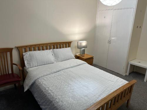 格拉斯哥Amazing Room in Glasgow City的一间卧室配有一张床和一张桌子上的台灯