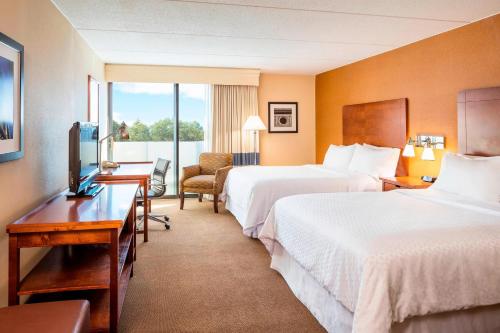 席勒公园芝加哥奥黑尔福朋喜来登酒店的酒店客房设有两张床和电视。