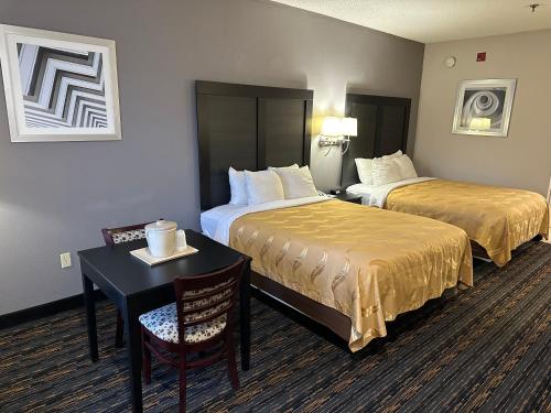 阿什兰Quality Inn Ashland的酒店客房,设有两张床和一张桌子及椅子