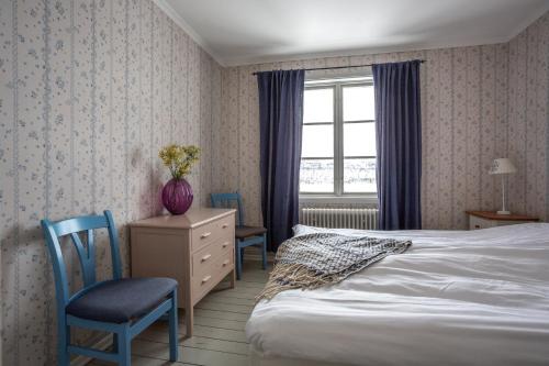 塔恩达勒Strandgården Fjällnäs的一间卧室配有一张床、两把椅子和一个窗户
