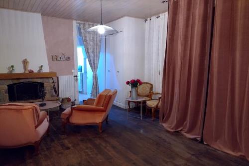 Saint-JustLe gite des galopins的客厅配有橙色椅子和壁炉