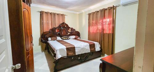Bayaguanacasa bayaguana的一间卧室配有一张带木制床头板的床