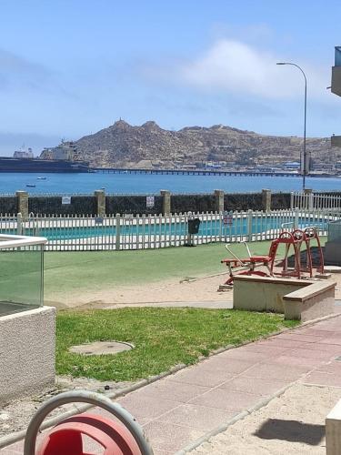 科金博Arriendo la herradura的两长椅的公园和大海的背景