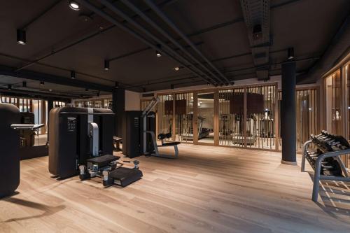 乌特斯克雷斯海姆慕尼黑无限酒店及会议度假酒店的铺有木地板的客房设有带健身器材的健身房