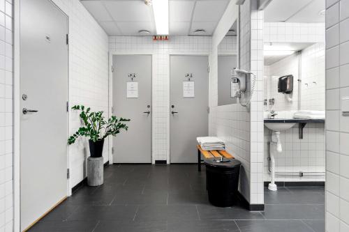 斯德哥尔摩Sure Hotel by Best Western Stockholm Alvsjo的浴室设有2个带长凳和水槽的摊位。