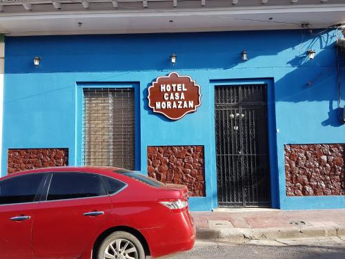 格拉纳达HotelCasaMorazanGranadaNicaragua的停在蓝色建筑前面的红色汽车