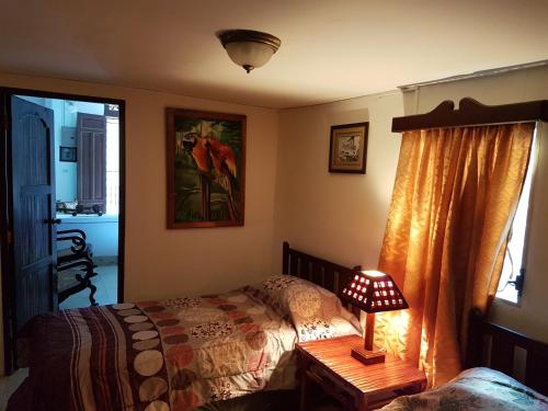 格拉纳达HotelCasaMorazanGranadaNicaragua的一间卧室配有一张床和一张桌子上的台灯