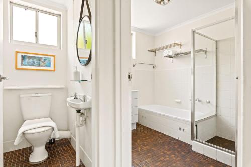 悉尼'Kangaroo Corner' Coastal Charm & Midcentury Flair的带浴缸、卫生间和盥洗盆的浴室
