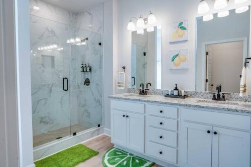 塔拉哈西Citrus Cottage: Comfy - Hwy 10 - Peaceful Retreat的白色的浴室设有2个盥洗盆和淋浴。