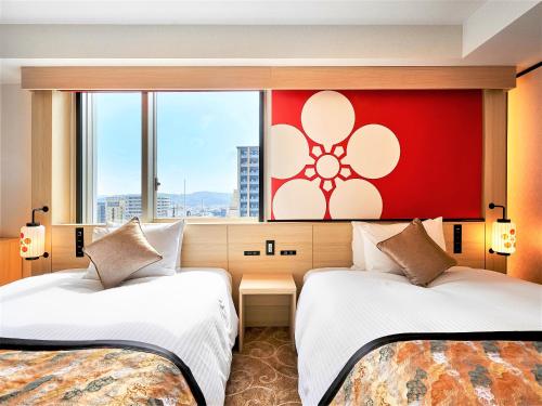 金泽Daiwa Roynet Hotel KANAZAWA-MIYABI的红色墙壁的酒店客房内的两张床