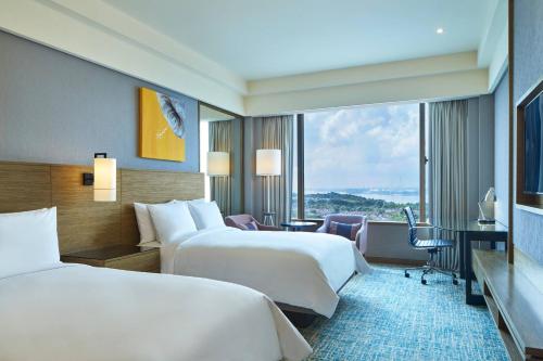 新山Renaissance Johor Bahru Hotel的酒店客房设有两张床和大窗户。