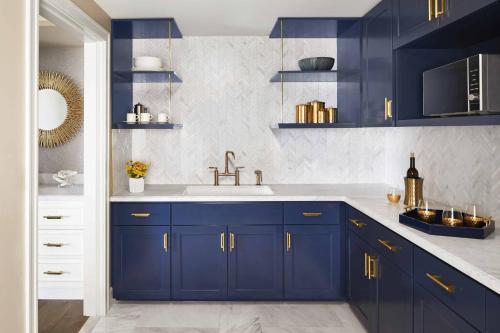 半月湾半月湾丽思卡尔顿酒店的厨房配有蓝色橱柜和水槽