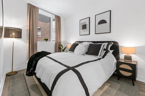 维多利亚Stylish One Bedroom Retreat, Downtown Victoria, Fitness Room, Incredible Location!的白色卧室配有一张大床和两盏灯。