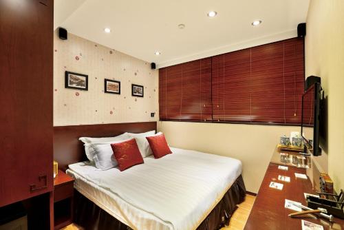 香港The Shai Red - formerly Mingle in The Shai的一间卧室配有带白色床单和红色枕头的床。