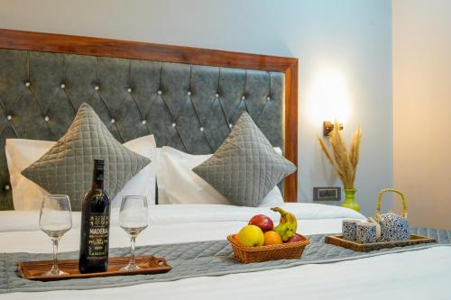 卡索尔Kasol ArtHouse - The Treasure of Himalayas的一张带一瓶葡萄酒和一篮水果的床