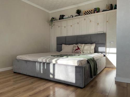 阿斯塔纳Уютная студия в скандинавском стиле в центре的卧室内的一张大床,铺有木地板
