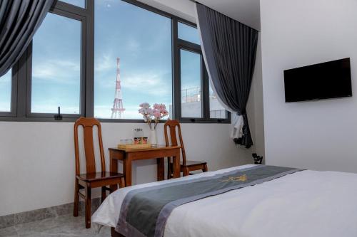 邦美蜀Lộc Sơn Hotel的一间卧室配有一张床和一张桌子及椅子
