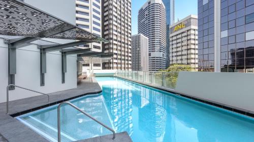 布里斯班Oaks Brisbane Aurora Suites的一座高楼建筑顶部的游泳池