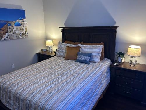 达拉斯On The Go Stays的一间卧室配有一张带条纹床罩的床和两盏灯。