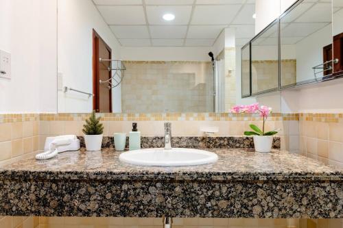 迪拜Moonlight Hostel JBR的浴室的柜台设有水槽和镜子