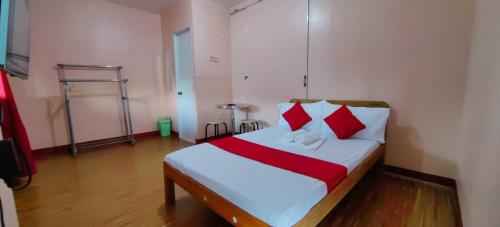 公主港OYO 1038 WILLIAM HEARTS PENSION的一间卧室配有红色和白色枕头的床