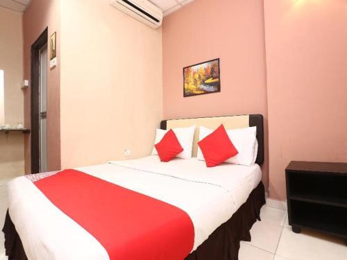 哥打巴鲁Destiny Riverside Hotel的一间卧室配有一张带红色枕头的大床
