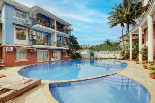 安君纳Genesis Leisure - Charming home-stays near Anjuna, Vagator & Assagao的大楼前的大型游泳池