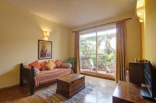 安君纳Genesis Leisure - Charming home-stays near Anjuna, Vagator & Assagao的带沙发和大窗户的客厅