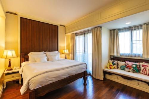 清迈禅凯姆精品酒店的一间卧室设有一张大床和两个窗户。
