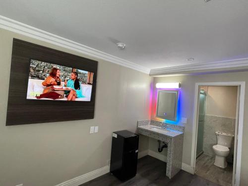 北山Diamond Inn的墙上设有1间带平面电视的浴室