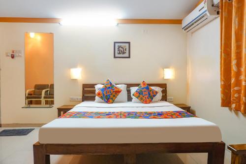 艾哈迈德讷格尔FabHotel Prime Vishwakirti Agri的一间卧室配有一张大床和两个枕头